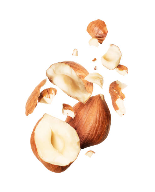 Hazelnuts crushed in the air close-up on white background
