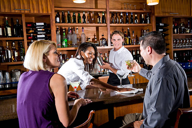 istock Happy bartenders mixing drink behind bar counter, couple chatting 104319065