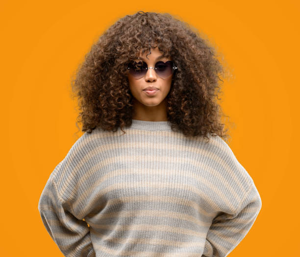 istock African american woman wearing a stripes sweater with a confident expression on smart face thinking serious 1043191502