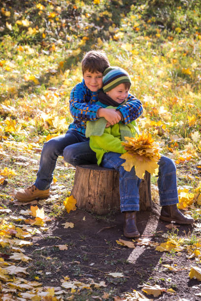 istock Two boys sitting together at the autumn park 1043202856