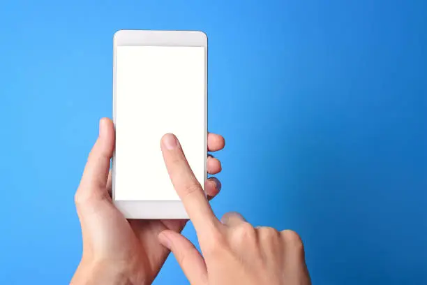 hand holding phone mobile and touching screen isolated on blue background, mock-up smartphone