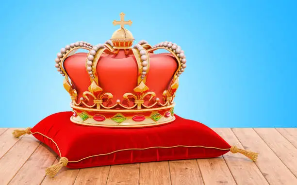 Photo of Golden Royal Crown on the red velvet pillow on the wooden table. 3D rendering