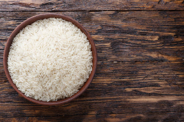 istock raw rice in a clay plate on a wooden background. 1043207276