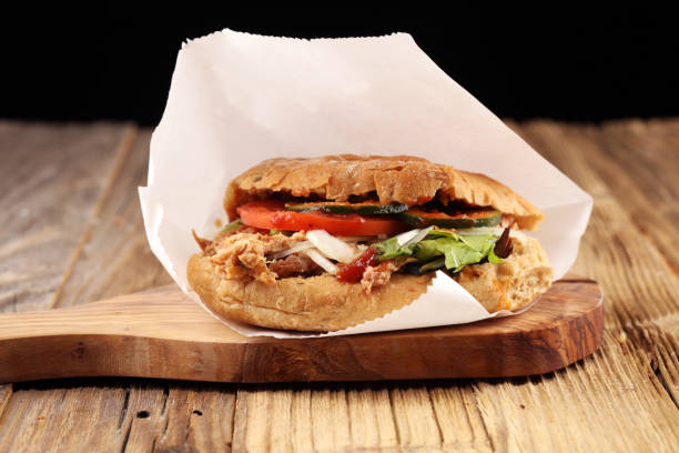 istock Pulled pork sandwiches with BBQ sauce, cabbage and pickles on wooden table 1043212124
