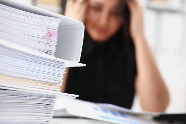 istock Tired and exhausted woman looks at documents propping up her head with her hands 1043218882