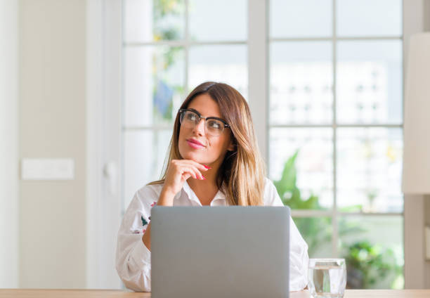 istock Young woman at home using laptop serious face thinking about question, very confused idea 1043222878