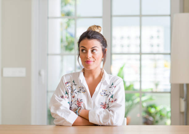 istock Young woman at home smiling looking side and staring away thinking. 1043225592