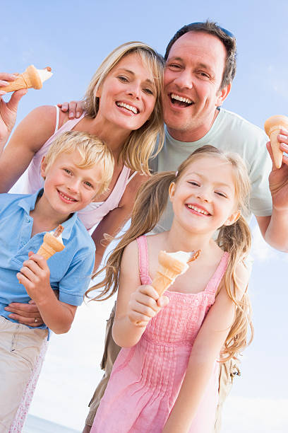 istock Family standing at beach with ice cream 104322932