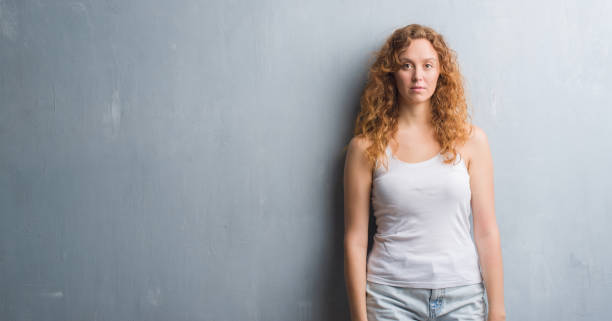 istock Young redhead woman over grey grunge wall with a confident expression on smart face thinking serious 1043231456