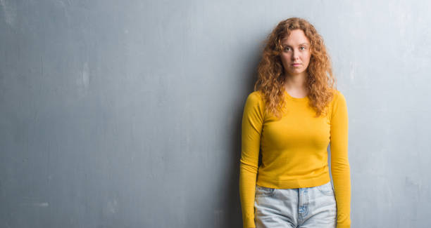 istock Young redhead woman over grey grunge wall with a confident expression on smart face thinking serious 1043231612