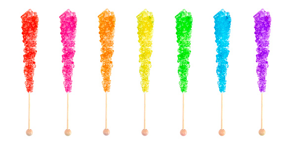 Row of Seven Rainbow Colored Rock Candies on a Stick