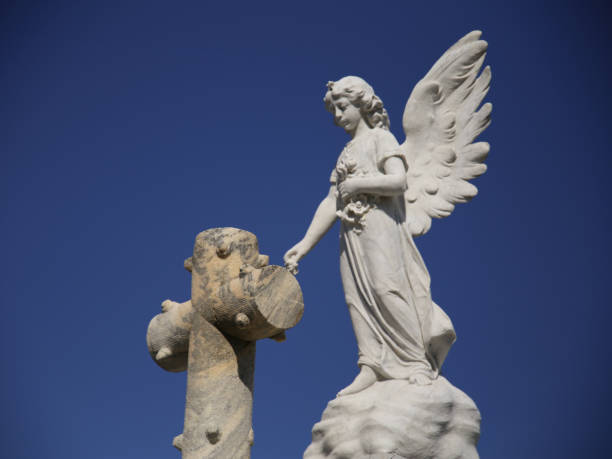 istock Angel Above Cross Cemetery Statue, Blue Sky Background 1043245112