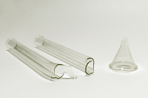 u-shaped absorption tube (broken in half) and small transparent funnel without trunk. obsolete laboratory glassware