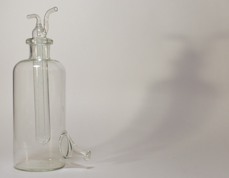 gas washing bottle, combined of flask and composite test tube with siphon (sealed ball-shaped tip). casts long shadow on background