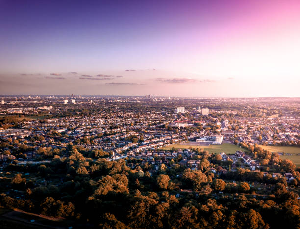 Sunrise aerial view of London City Skyline and famous skyscrapers in the the background above a London housing estate. stock photo