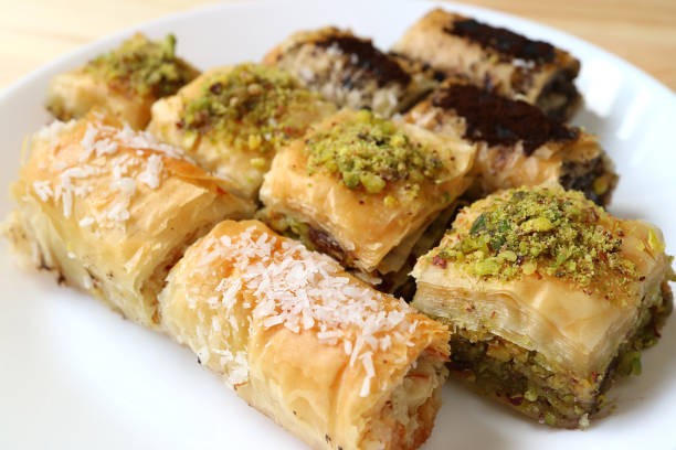 istock Different types of mouthwatering Baklava pastries served on white plate, selective focus and blurred background 1043266174