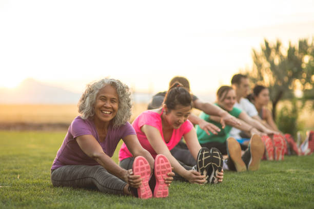 istock Group doing co-ed yoga outside in the morning 1043266324