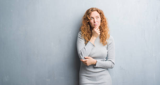 istock Young redhead woman over grey grunge wall serious face thinking about question, very confused idea 1043266434
