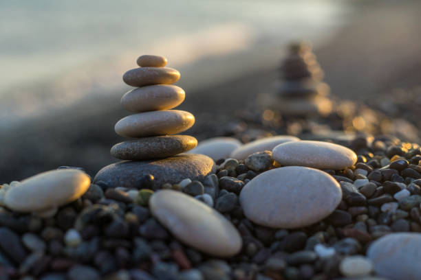 istock Stones pyramid on pebble beach symbolizing stability, zen, harmony, balance. Shallow depth of field. 1043269094
