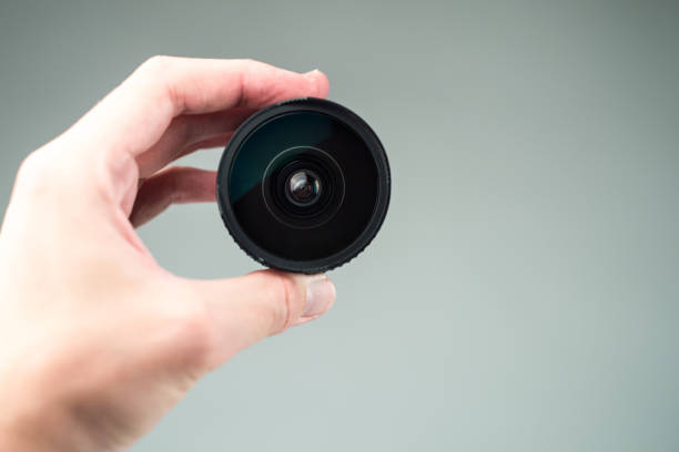 istock Old lens in hands on a white background 1043269262