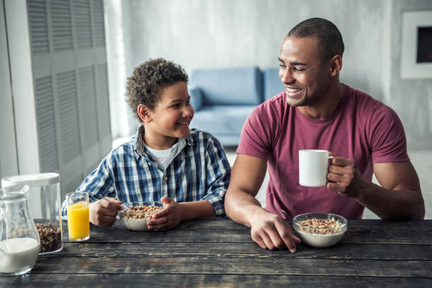 vater und sohn - breakfast eating people teens stock-fotos und bilder