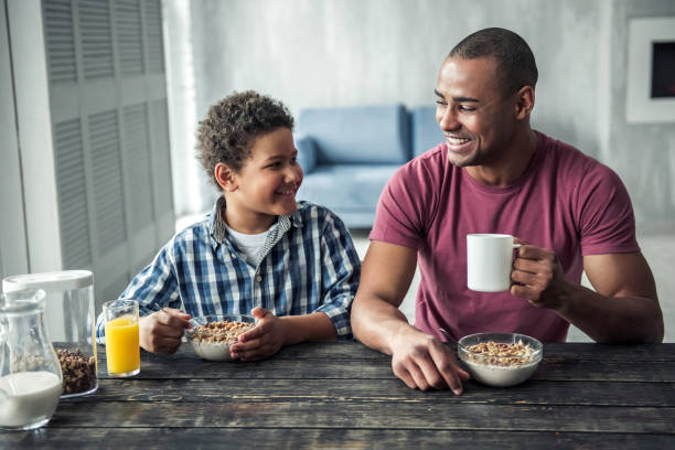 father and son - breakfast eating people teens imagens e fotografias de stock