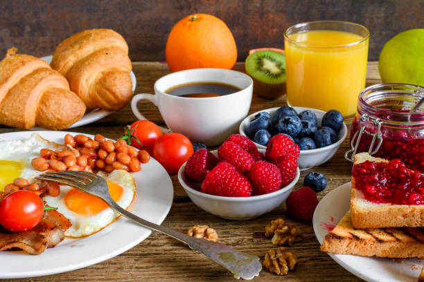 영어 아침 식사-튀긴된 계란, 콩, 토마토, 커피, 베이컨, 토스트와 오렌지 주스, 신선한 과일 포크로 열매 - breakfast bacon eggs toast 뉴스 사진 이미지