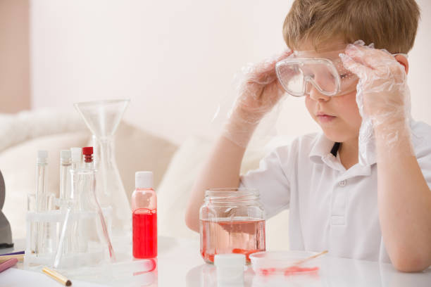 istock Cute kid boy in glasses making science experiments. Little child working with liquids. 1043279162