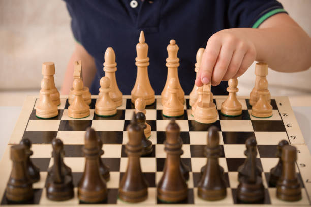 istock Boy playing chess in the room. Little clever child thinking while playing chess at home. Education concept. 1043281538
