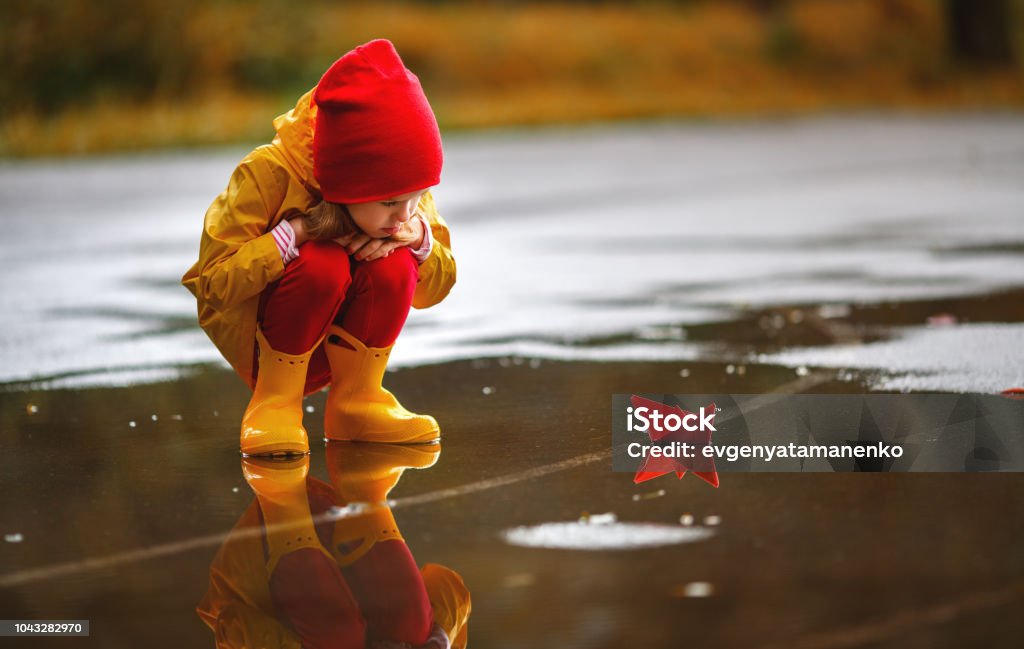 fille enfant heureux avec bateau en papier dans la flaque d’eau à l’automne sur la nature - Photo de Enfant libre de droits