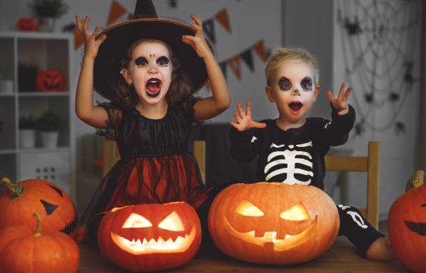 楽しいハロウィンをお過ごし下さい！魔女やカボチャ、暗闇の中キャンドルのスケルトンの衣装の子どもたち - pumpkin small orange holiday ストックフォトと画像