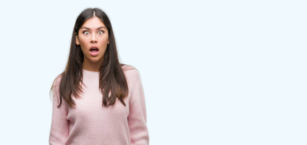 istock Young beautiful hispanic woman wearing a sweater afraid and shocked with surprise expression, fear and excited face. 1043291238