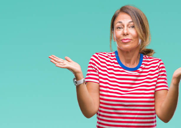 istock Middle age senior hispanic woman over isolated background clueless and confused expression with arms and hands raised. Doubt concept. 1043295364