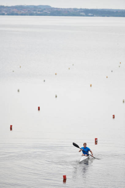 Beautiful view of calm lake and kayaker floating in boat during rowing competition