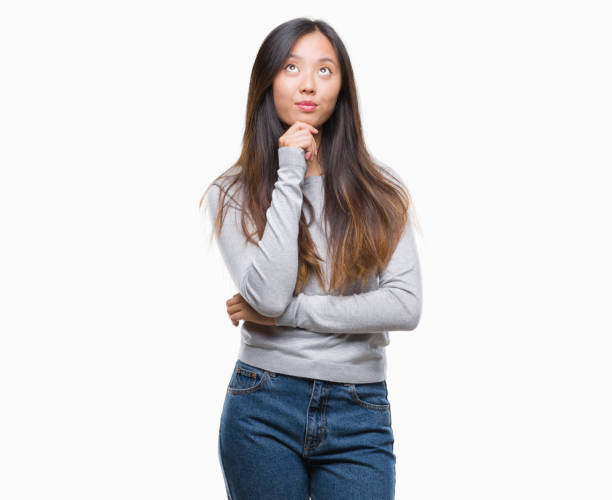 istock Young asian woman over isolated background with hand on chin thinking about question, pensive expression. Smiling with thoughtful face. Doubt concept. 1043299532