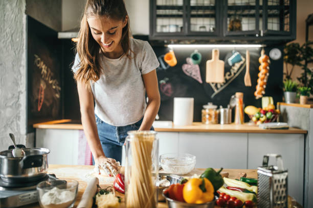 istock Young woman making pizza at home 1043299600