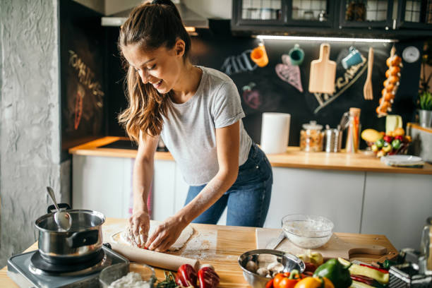 istock Young woman making pizza at home 1043299728
