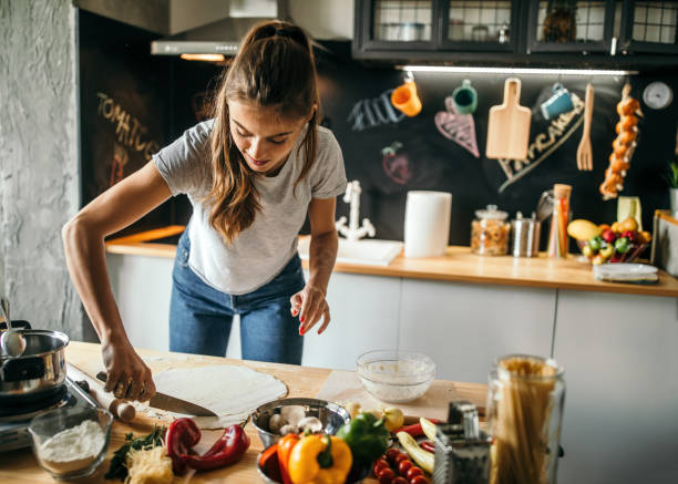 istock Young woman preparing pizza 1043300140
