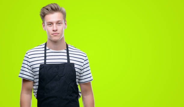 istock Young handsome blond man wearing apron with a confident expression on smart face thinking serious 1043303108
