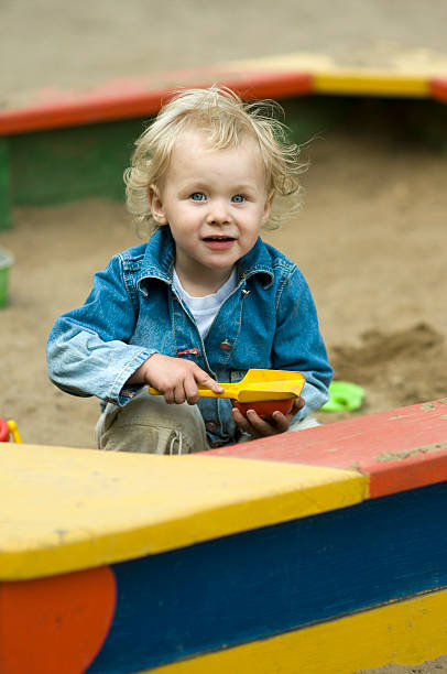 Cute Blond Child Playing in Sandbox stock photo