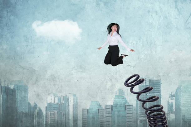 istock Female entrepreneur jumps by using a big spring 1043313658