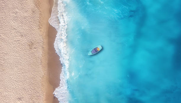 Boat on the water surface from top view. Turquoise water background from top view. Summer seascape from air. Travel concept and idea