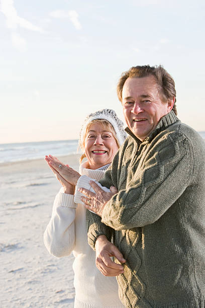 istock Senior couple in sweaters together on beach 104331442