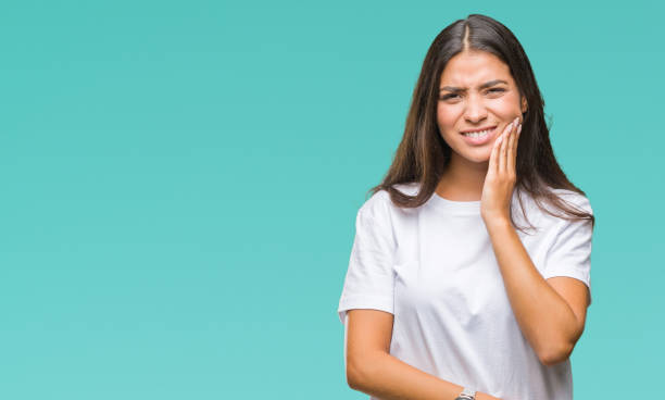 jeune belle femme arabe sur fond isolé touchant la bouche avec la main avec une expression douloureuse à cause de maux de dents ou d’une maladie dentaire sur les dents. concept de dentiste. - dentition humaine photos et images de collection