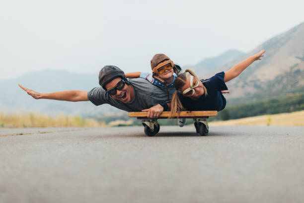 los niños y papá volando en un carro de prensa - pleasure launch fotografías e imágenes de stock