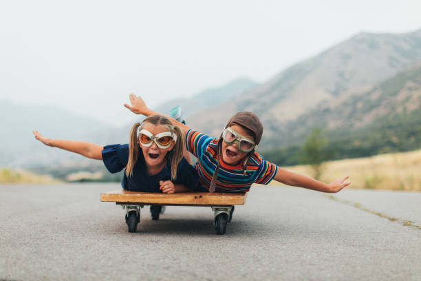 young kids flying on a press cart - teamwork occupation creativity taking off imagens e fotografias de stock