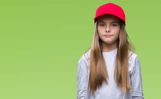 istock Young beautiful girl wearing red cap isolated background with serious expression on face. Simple and natural looking at the camera. 1043334688