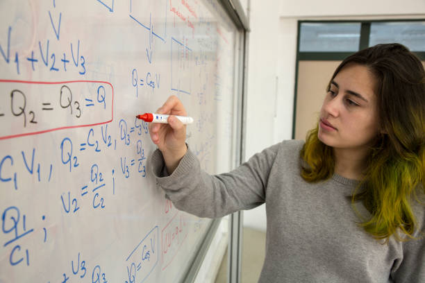 istock Female Student writing mathematical formula in front of the whiteboard 1043337712