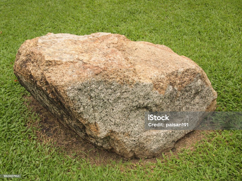 big stone on the grass Brown Stock Photo