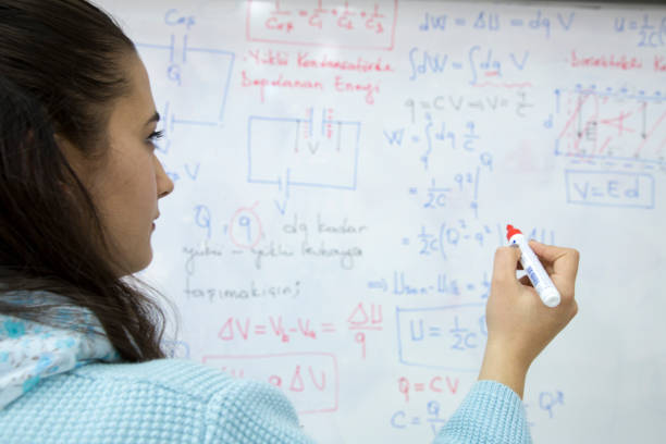 istock Female Student writing formula in front of the whiteboard 1043337986